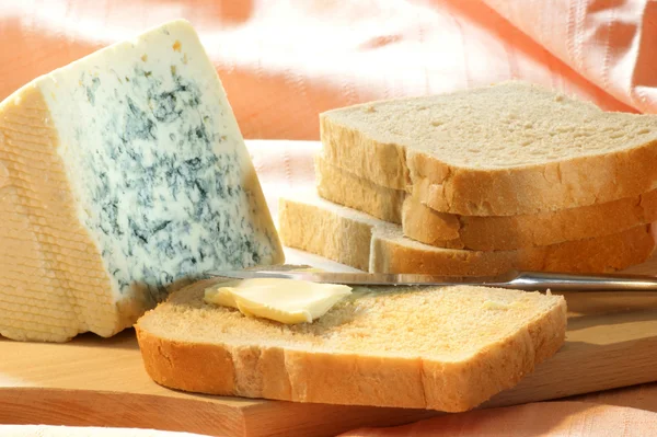 Placa de madeira com algum queijo de molde azul — Fotografia de Stock