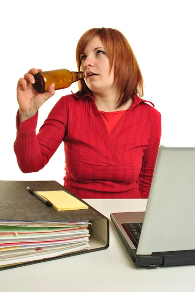 Uma jovem mulher bebendo em sua mesa de escritório — Fotografia de Stock