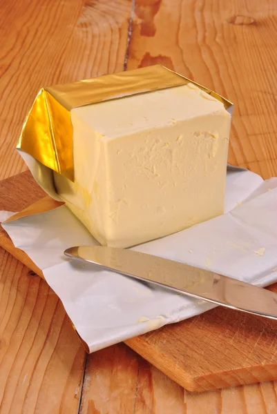 Un cubetto di margarina e un coltello da cucina Fotografia Stock