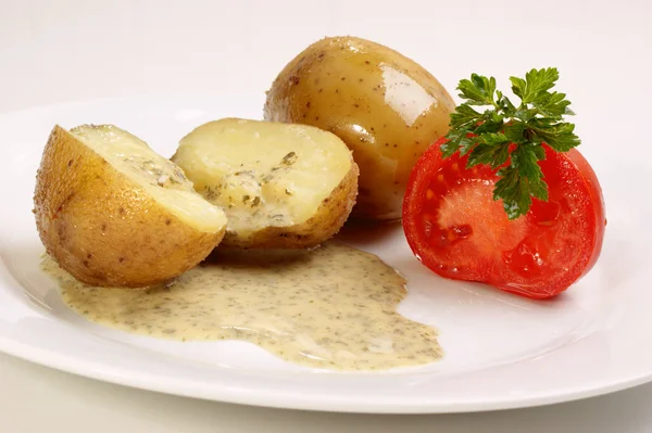 Kokt potatis med persiljesås på en tallrik — Stockfoto