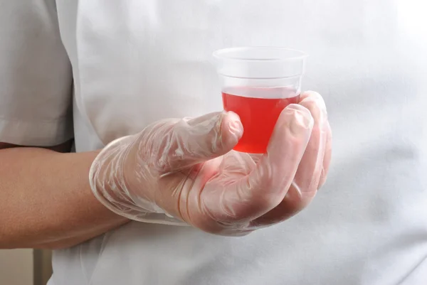 Health care staff with disposable glove and red medicine — Stock Photo, Image