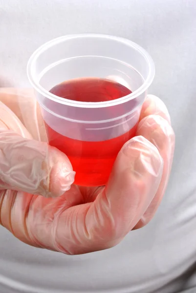 Tek kullanımlık eldiven ve kırmızı ilaç ile sağlık personeli — Stok fotoğraf