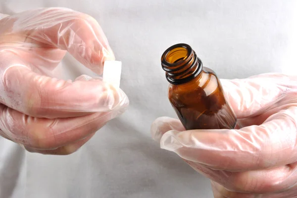 Personnel de santé avec gant jetable avec bouteille de pilule ouverte — Photo
