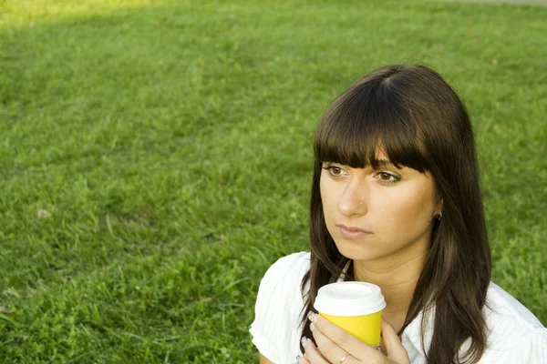 Menina bonita no parque com café — Fotografia de Stock
