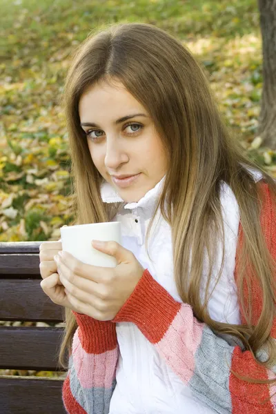 Flicka håller kaffekoppen och ler — Stockfoto