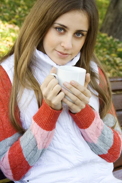Chica sosteniendo la taza de café y sonriendo — Foto de Stock