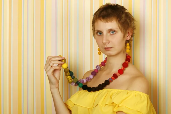Młoda Kobieta Przed Żółte Paski Ściany Żółtą Bluzkę Nagie Ramiona — Zdjęcie stockowe