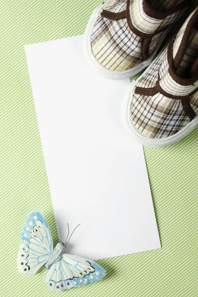 彼の誕生日や新生児は靴を子供と青い蝶の隣にお祝いの言葉のテキスト メッセージを書くためのはがき — ストック写真