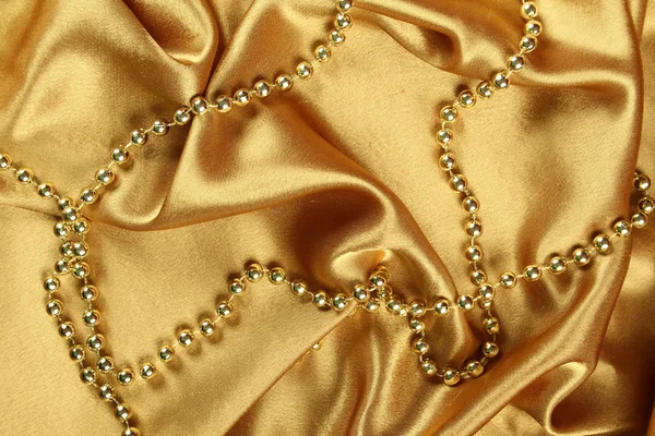 Sfondo Stoffa Oro Cui Poggiano Perline Oro — Foto Stock