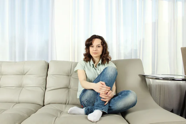 Genç kadın bir kanepede — Stok fotoğraf