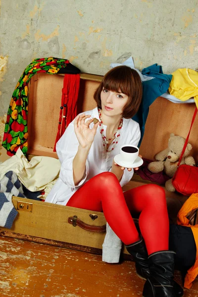 Mulher atraente sentada em uma mala — Fotografia de Stock