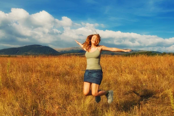 Happy young woman in a field — Stock Photo, Image