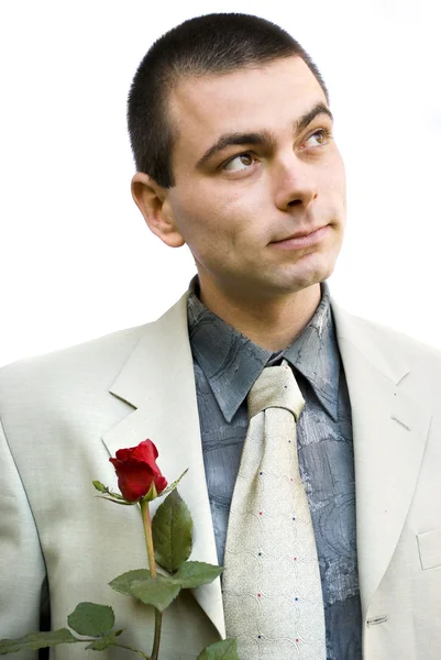 赤薔薇見上げる手で保持している若いロマンチックなビジネス男 — ストック写真