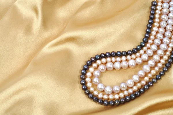带上它的珍珠项链金丝绸背景 — 图库照片