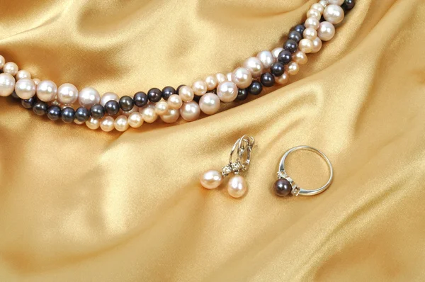 带上它的珍珠项链金丝绸背景 — 图库照片