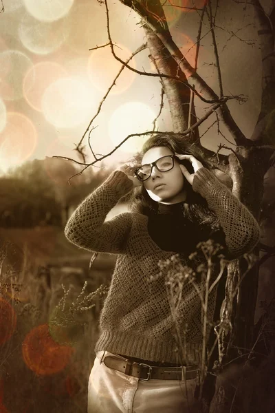 Мечтающая девушка стоит возле дерева в лесу — стоковое фото