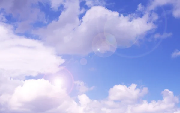 En blå tonad solig himmel med moln och axlar av solljuset strålar — Stockfoto