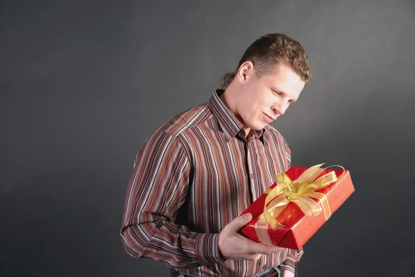 Ein Mann betrachtet ein Geschenk mit schummrigem Blick — Stockfoto