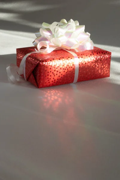 Cadeau dans l'emballage est éclairé les rayons d'un soleil — Photo