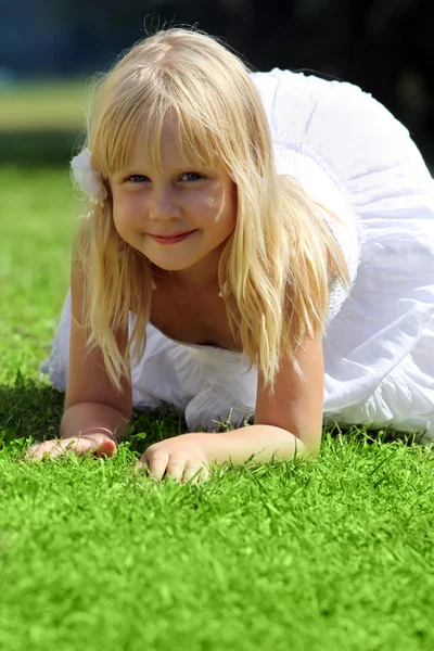 Leende liten flicka avkopplande utomhus — Stockfoto