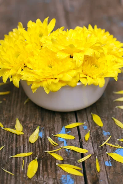 Gele bloemen op oude houten bord — Stockfoto