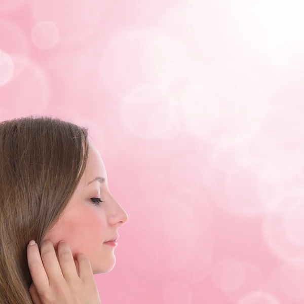 Beautiful young woman dreams - on soft pink blurred background — Stock Photo, Image