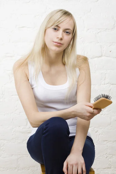 Piękna kobieta z blond włosy trzymając grzebień — Zdjęcie stockowe