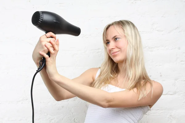 Woman holding hairdryer (focus on the hairdryer) — Stock Photo, Image