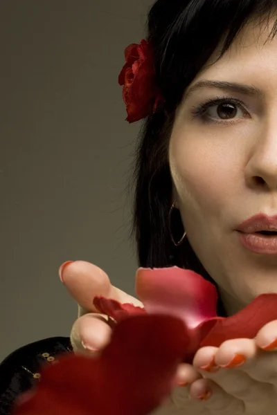 Güzel tutkulu bir kadın kırmızı gül yaprakları kisses — Stok fotoğraf