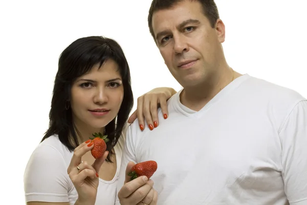 Casal jovem em camiseta branca com morangos vermelhos isolados — Fotografia de Stock