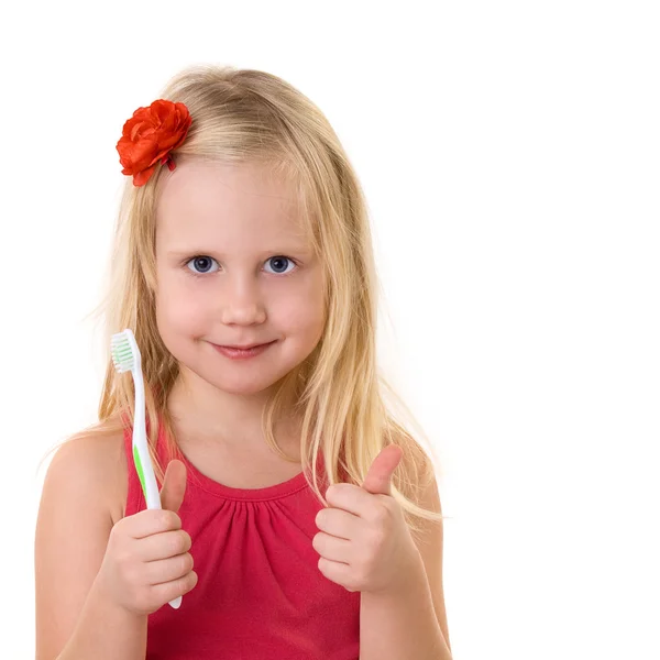 Child with a toothbrush shows thumbs up — Stock Photo, Image