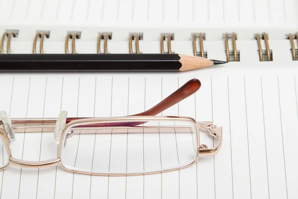 Een dagboek met een potlood en glazen — Stockfoto