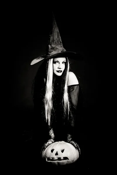 Bruxa de Halloween com um crânio sobre fundo preto com fumaça — Fotografia de Stock