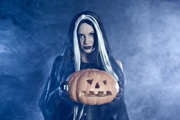 Retrato bruxa de Halloween com uma abóbora — Fotografia de Stock
