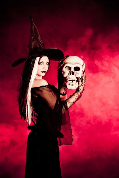 Bruxa halloween com um crânio — Fotografia de Stock