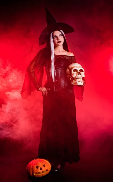 Bruxa de Halloween com um crânio e abóbora — Fotografia de Stock