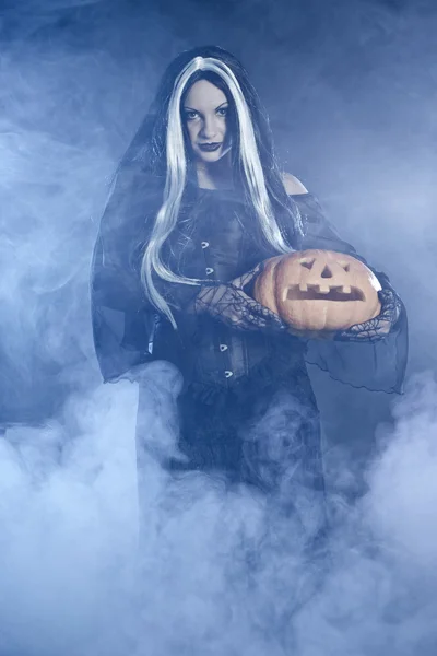 Retrato bruxa de Halloween com uma abóbora — Fotografia de Stock