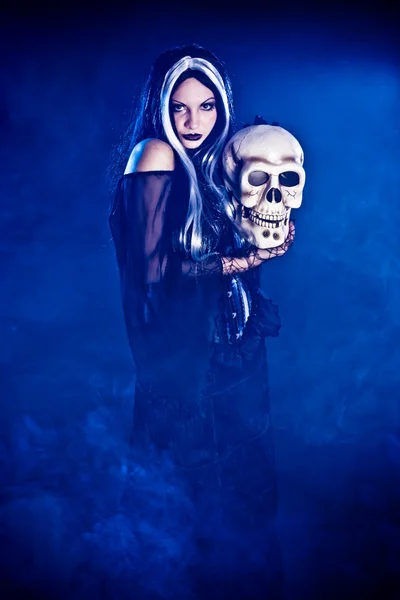 Halloween-Hexe mit Totenkopf auf schwarzem Hintergrund — Stockfoto