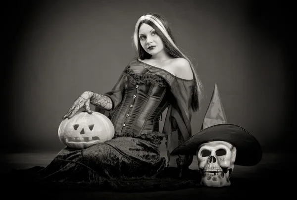 Bruxa de Halloween com um crânio e abóbora — Fotografia de Stock
