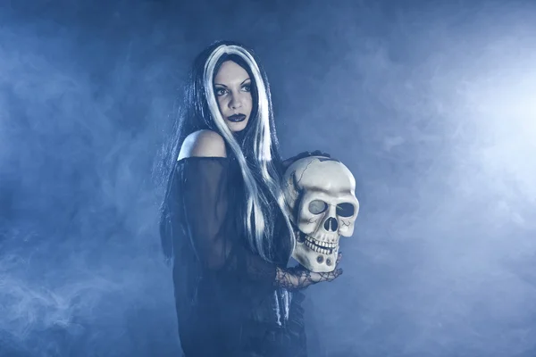 Bruxa halloween com um crânio — Fotografia de Stock