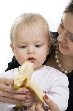 The child eats a banana. clipart