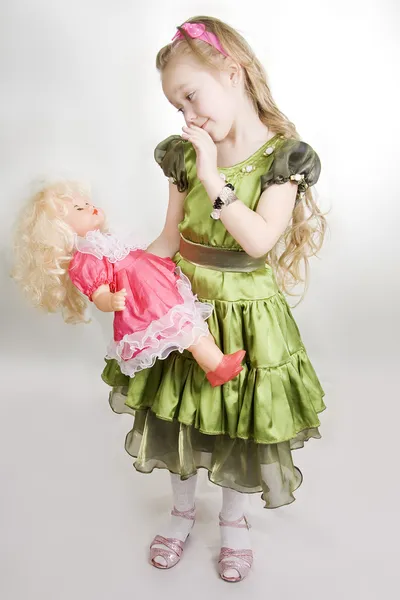 Het meisje speelt met een pop — Stockfoto