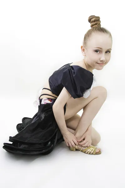 The dancing girl has sat down to clasp a shoe — Stock Photo, Image