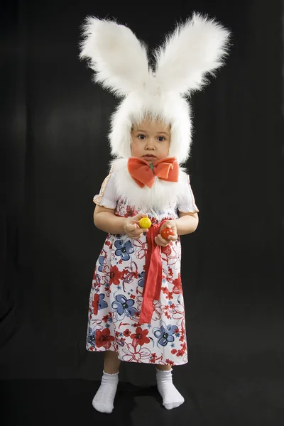 El niño en el traje del conejo el fondo negro — Foto de Stock
