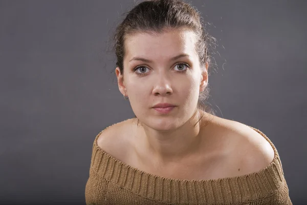 Den unga allvarliga kvinnan. isolerad på grå. — Stockfoto