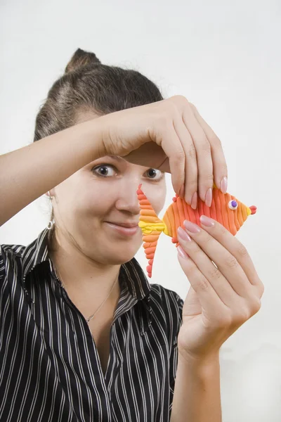 The young teacher shows clay fish. — Stock Photo, Image