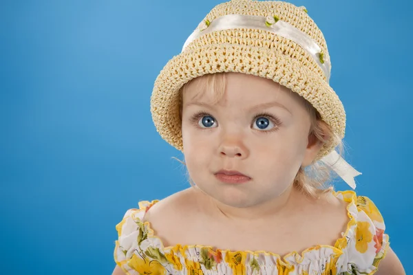 Pequena menina adorável em um fundo azul . — Fotografia de Stock