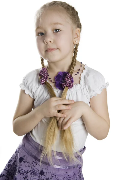Kleines blondes Mädchen mit langen Zöpfen auf weißem Hintergrund — Stockfoto