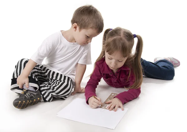 Brother and sister draws on a ruler Royalty Free Stock Photos