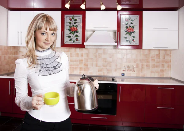 Молодая женщина на кухню в красно-белый цвет — стоковое фото